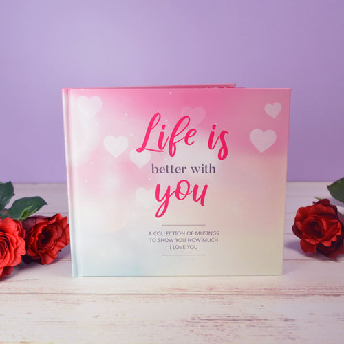 Life is better with you book on display with red roses